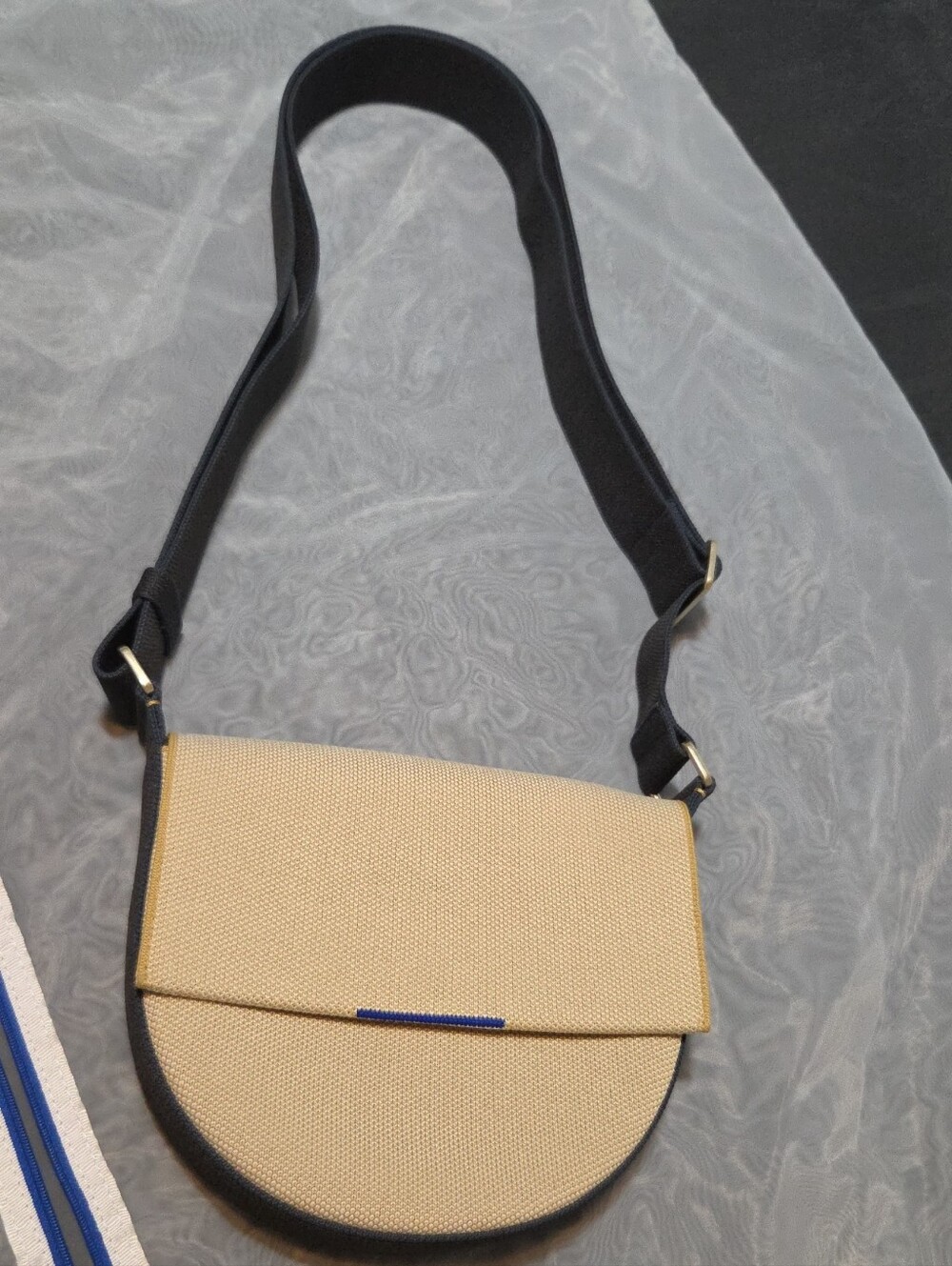 Beige Crossbody Saddle Bag with Black Strap and Blue Trim